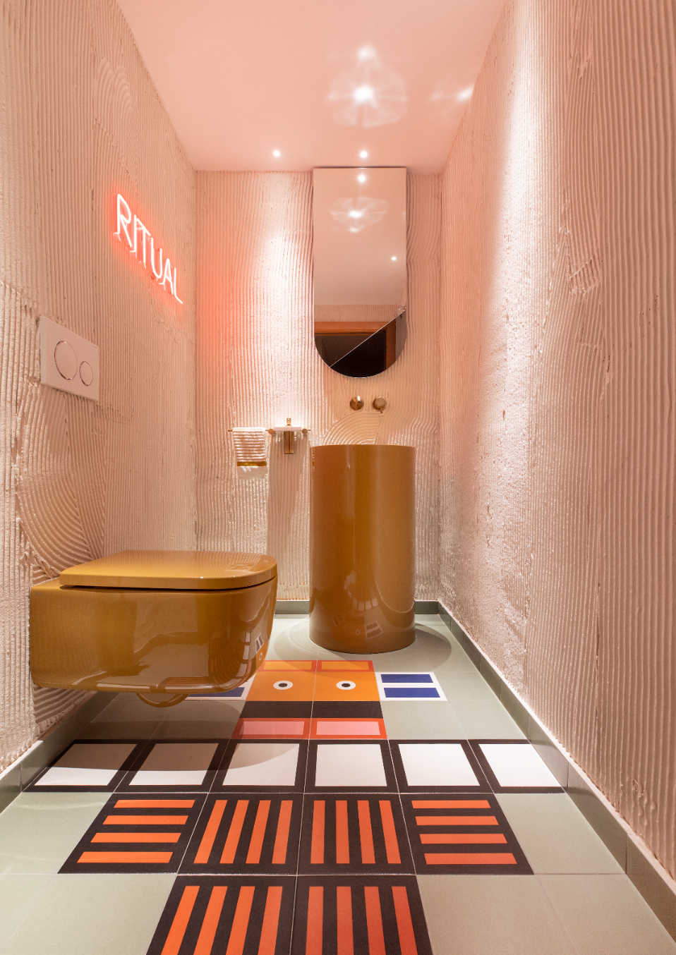 Baño pequeño en rosa con neón y alfombra gráfica