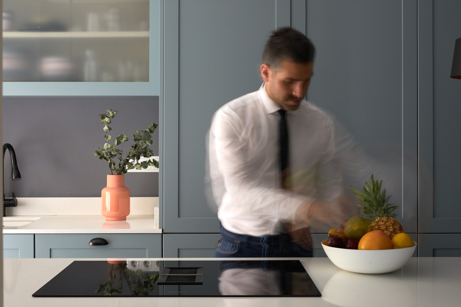 Cocina con frente de armarios gris azulado y encimera blanca