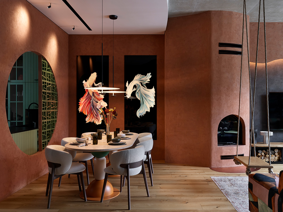 Comedor con paredes de terracota, ventana circular y mesa ovalada