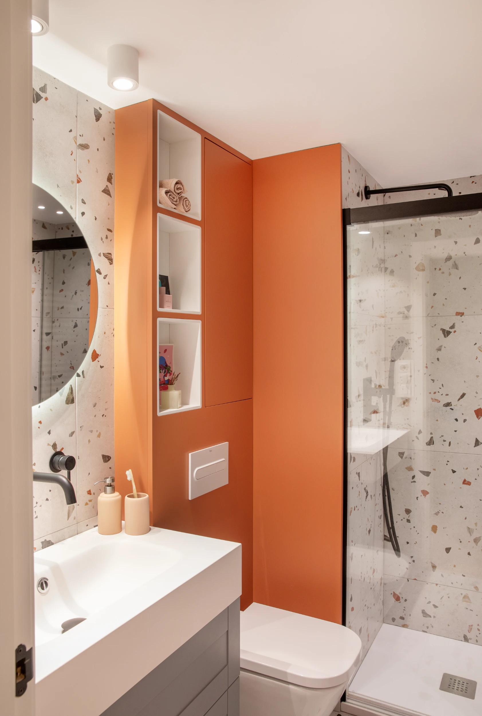 Baño con hornacina naranja y terrazo