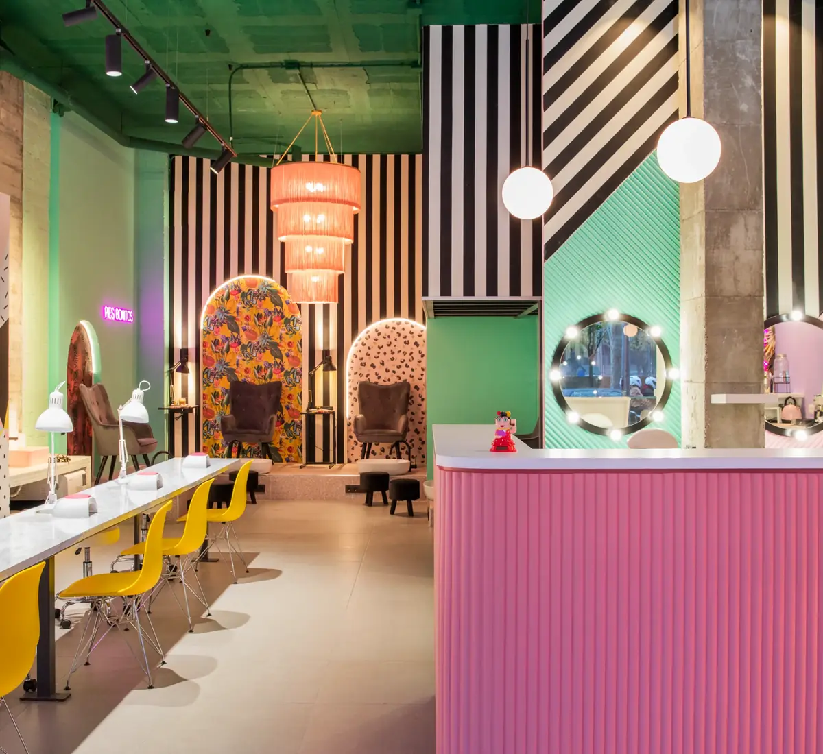 Puestos de manicura y mostrador rosa con paredes geométricas en The Beauty Place