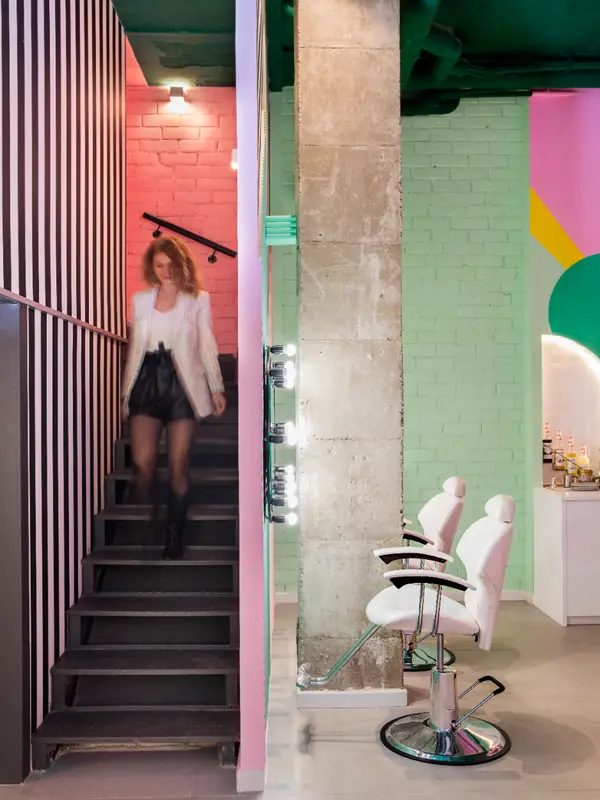 Escalera y zona de peluquería con paredes geométricas en The Beauty Place