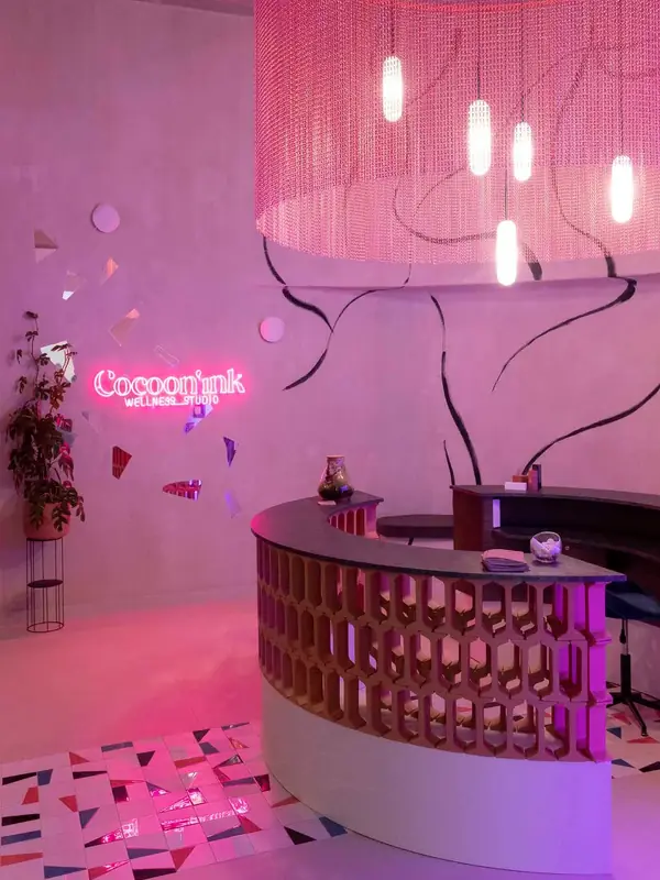 Recepción con lámpara de flecos rosa y celosía cerámica en Cocoon'ink