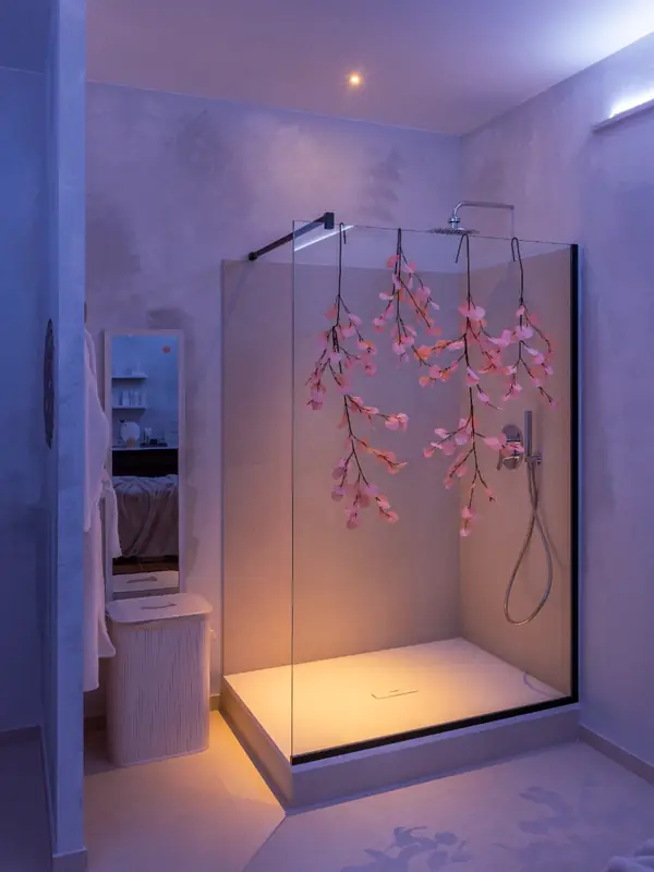 Ducha con flores colgantes y luz violeta en el estudio Cocoon'ink