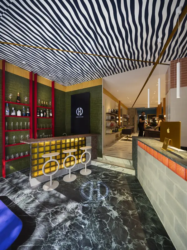 Coctelería de bienvenida con techo de rayas y suelo de mármol verde en Hair Cut Day Gràcia