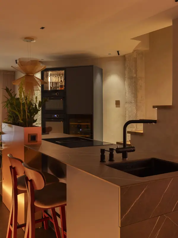 Cocina con barra de piedra y grifería negra en el showroom