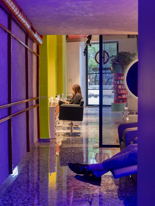 Pasillo de terrazo y columnas amarillas en Hair Cut Day Letamendi