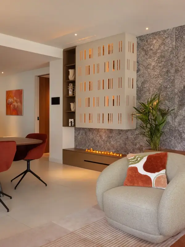 Comedor y chimenea con celosía blanca en una vivienda de Sarrià