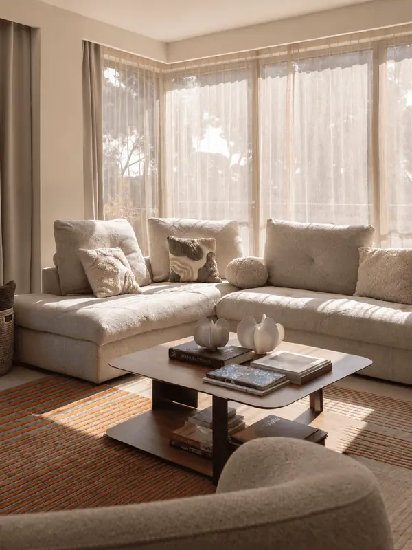 Salón luminoso con sofá en L y mesa baja en una vivienda de Sarrià