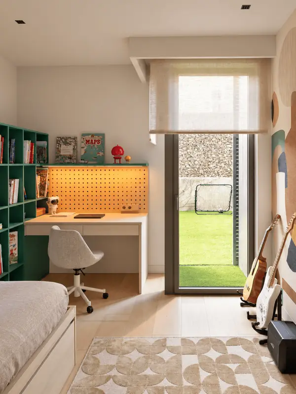 Habitación juvenil con escritorio y salida al jardín en una vivienda de Sarrià
