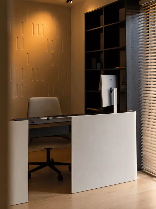 Despacho con escritorio blanco y librería oscura en una vivienda de Sarrià, Barcelona