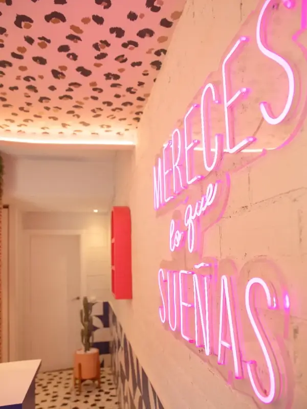 Neón «Mereces lo que sueñas» y techo estampado en el estudio de la chica de las cejas