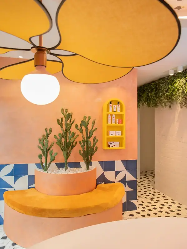 Jardinera curva con cactus y lámpara en forma de flor en el estudio de la chica de las cejas, Rubí